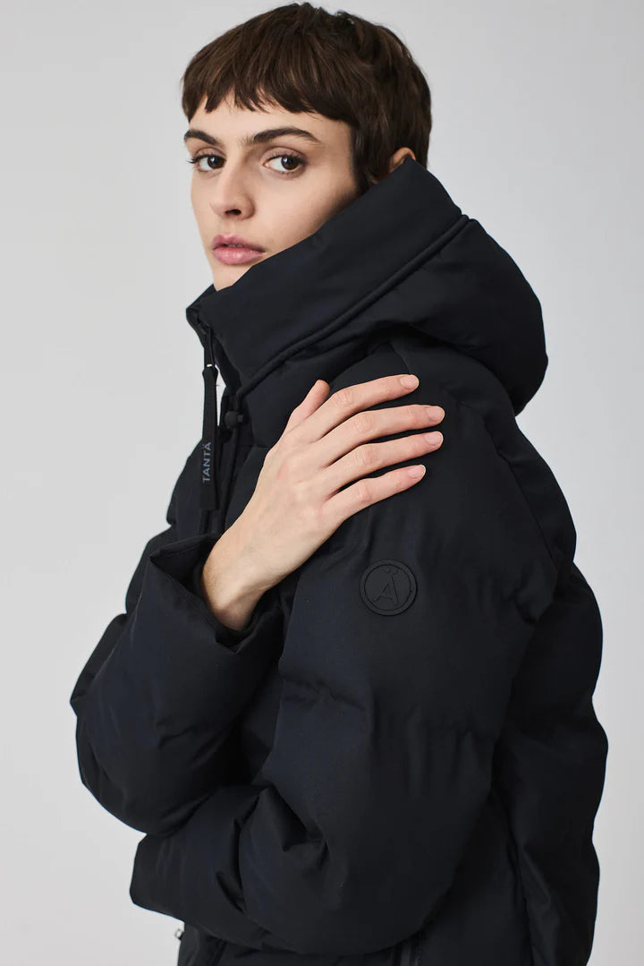 Person wearing a black puffer jacket on a plain background