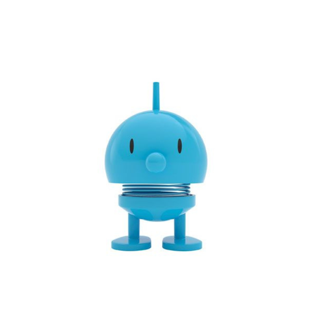 Blue bobblehead toy with a spring and short legs; simple, cartoonish face.