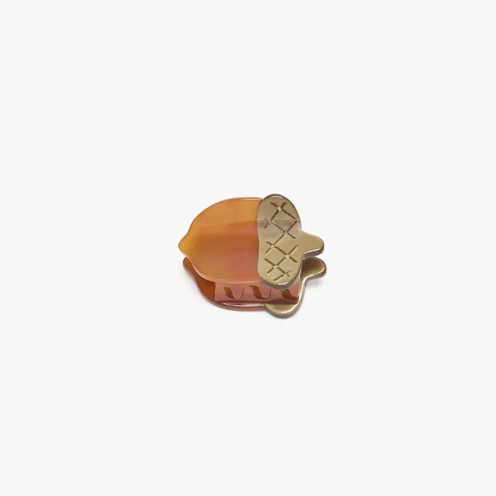 Hair clip with a gold and orange design on a white background