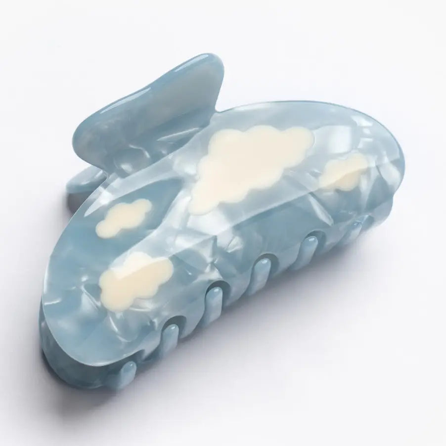 Clear plastic clip with cloud designs on a white background