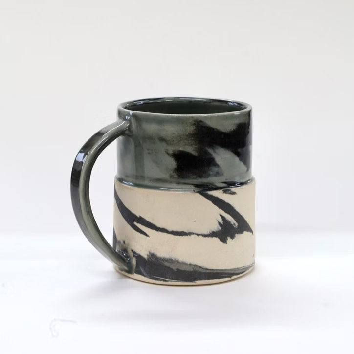 Ceramic mug with black and white abstract design on a white background