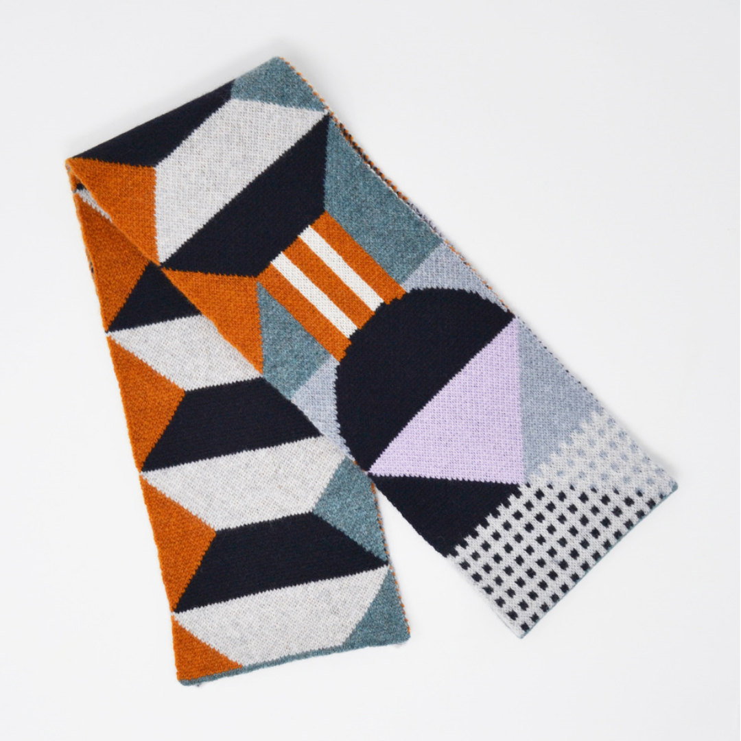 Geometric patterned knit scarf in orange, teal, gray, purple, and black.