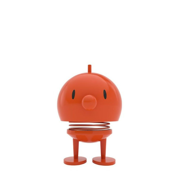 Orange bobblehead toy with simple face and spring body.