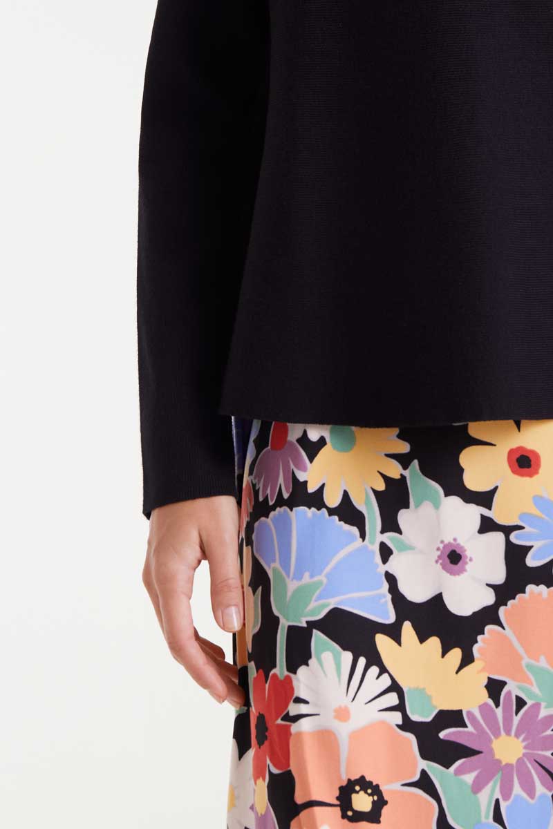 Close-up of a floral skirt with a black top on a white background