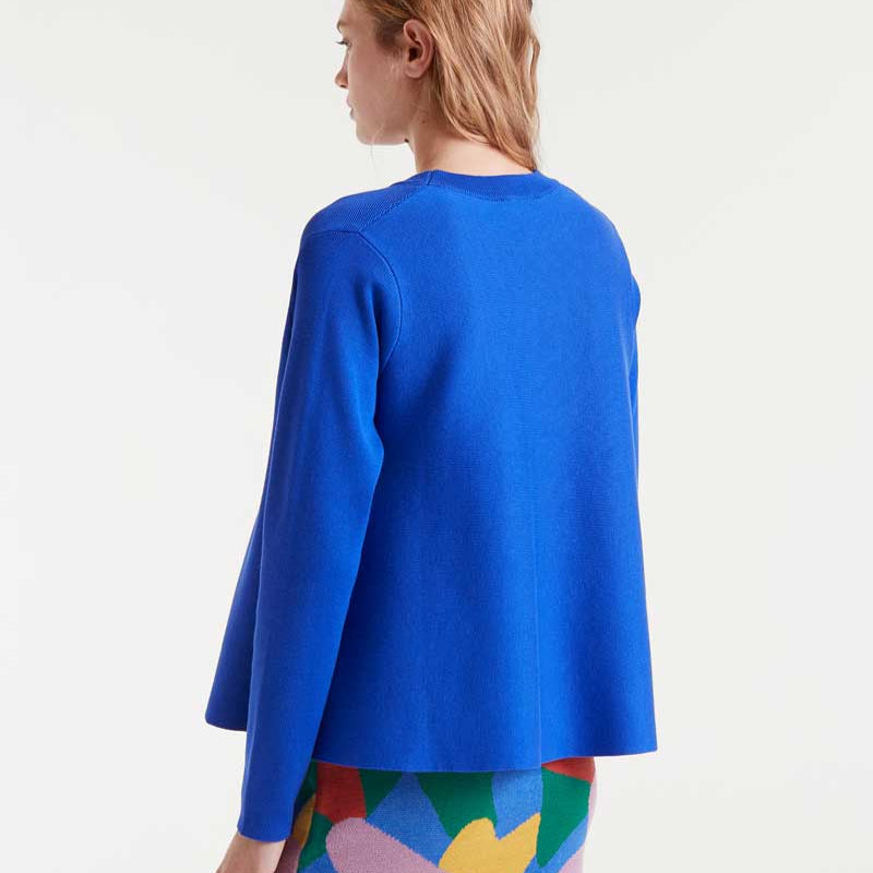 Woman wearing a blue top and colorful skirt on a white background