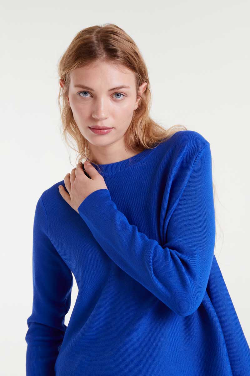 Woman wearing a blue sweater against a white background