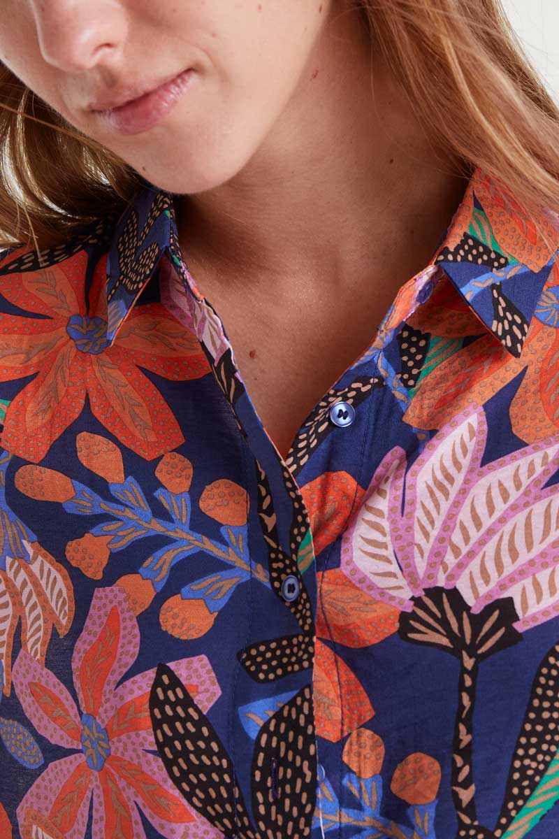 Close-up of a person wearing a colorful floral patterned shirt.