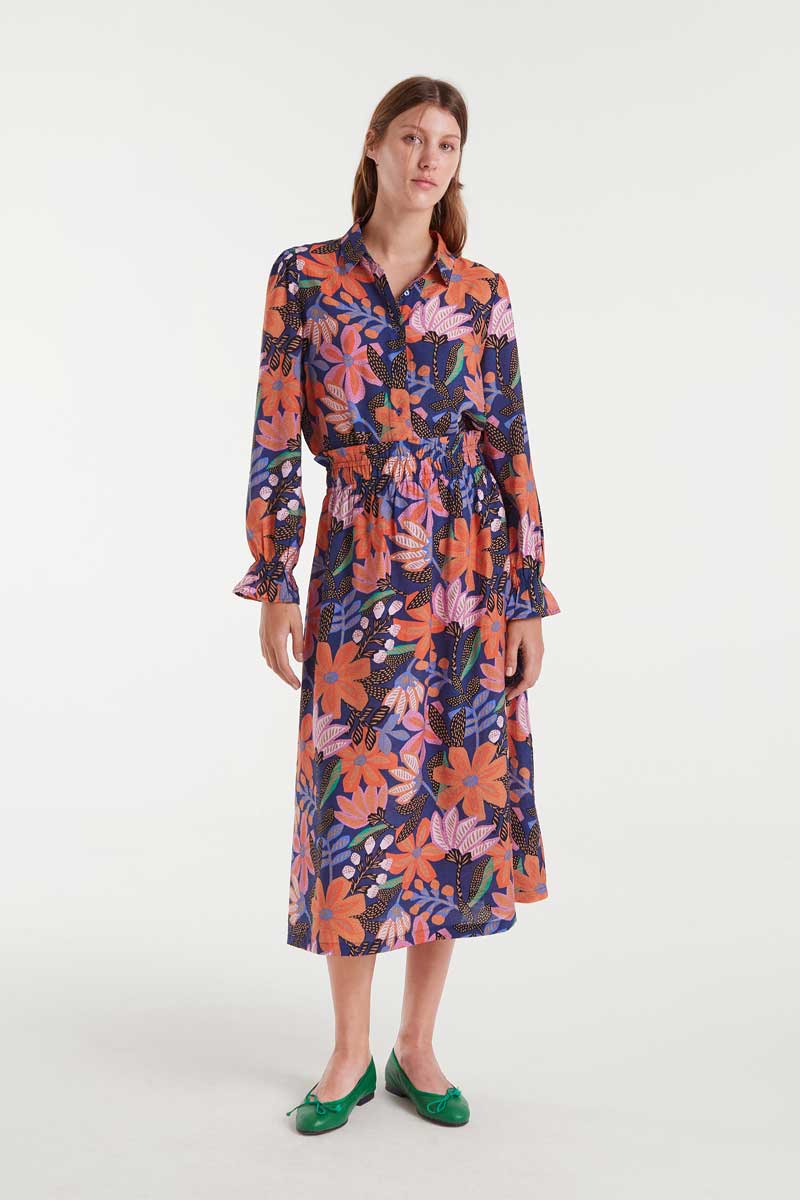 Woman wearing a floral blouse and skirt  on a white background