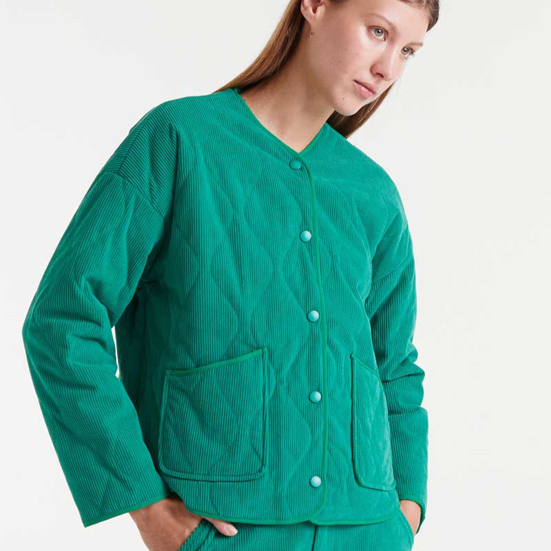 Person wearing a green corduroy jacket on a white background