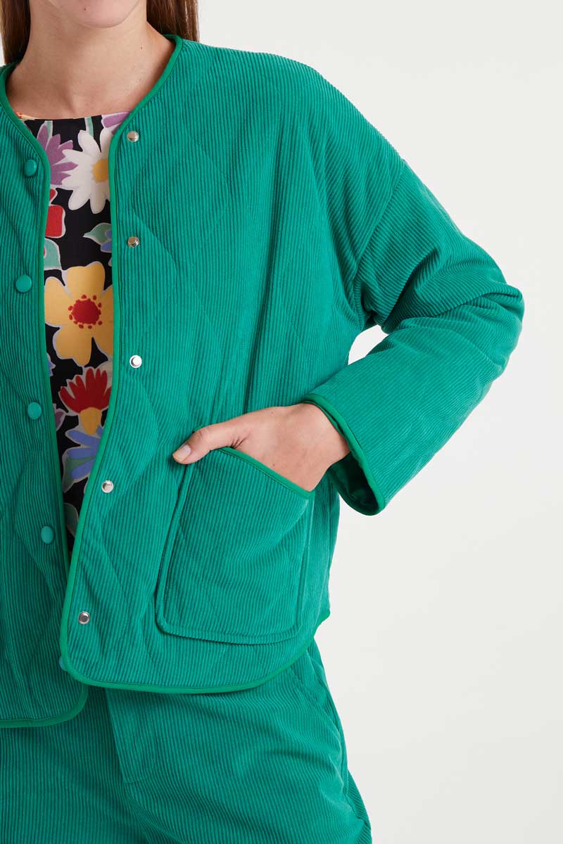 Green corduroy jacket worn by a person on a white background