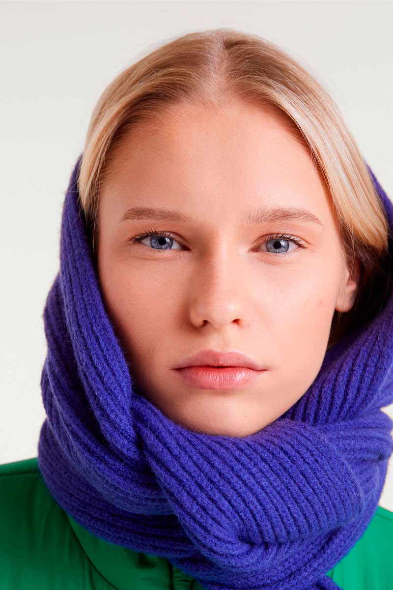 Person wearing a blue scarf with a plain background