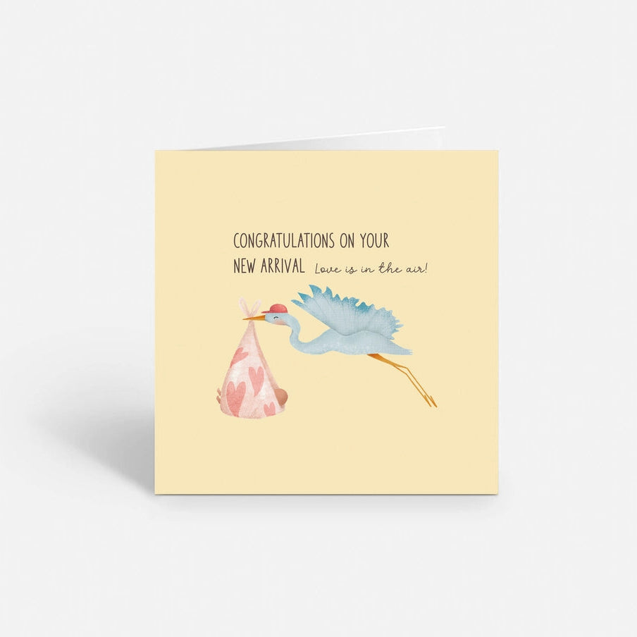Baby announcement card featuring a stork carrying a pink bundle.