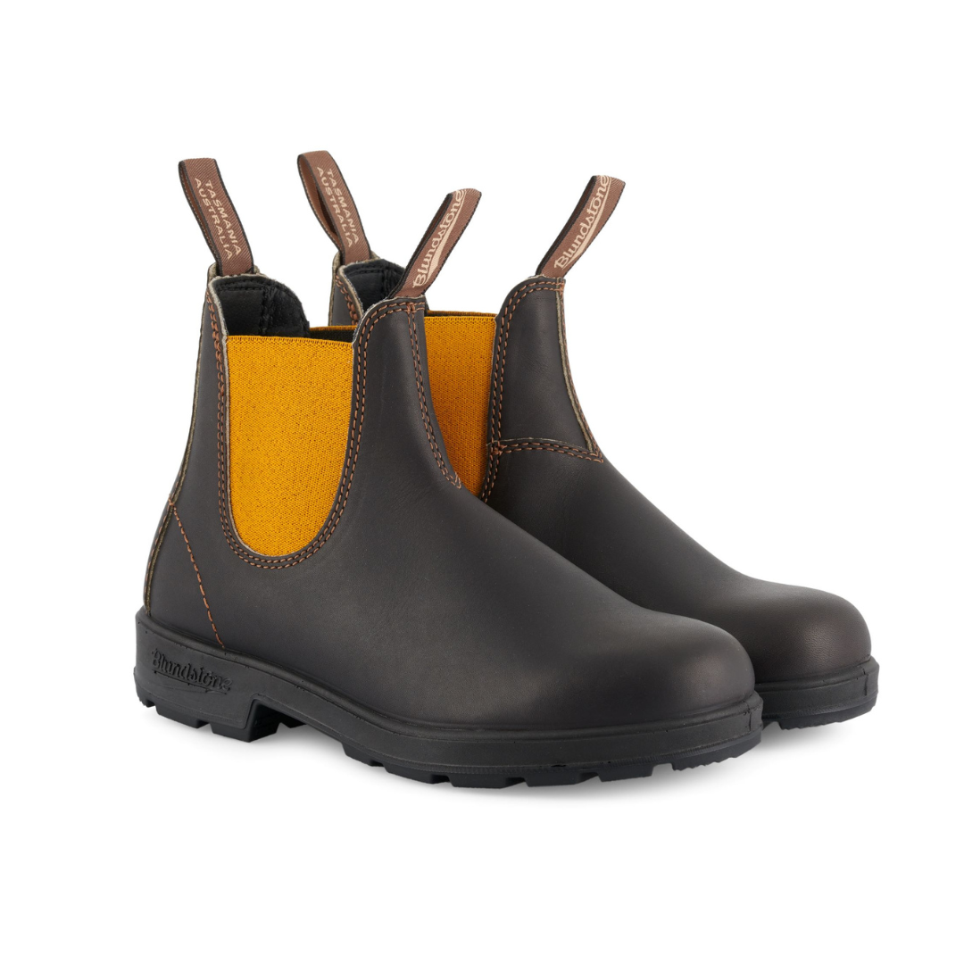 Pair of Blundstone Chelsea boots in dark brown leather with mustard yellow elastic side panels and a rugged outsole.