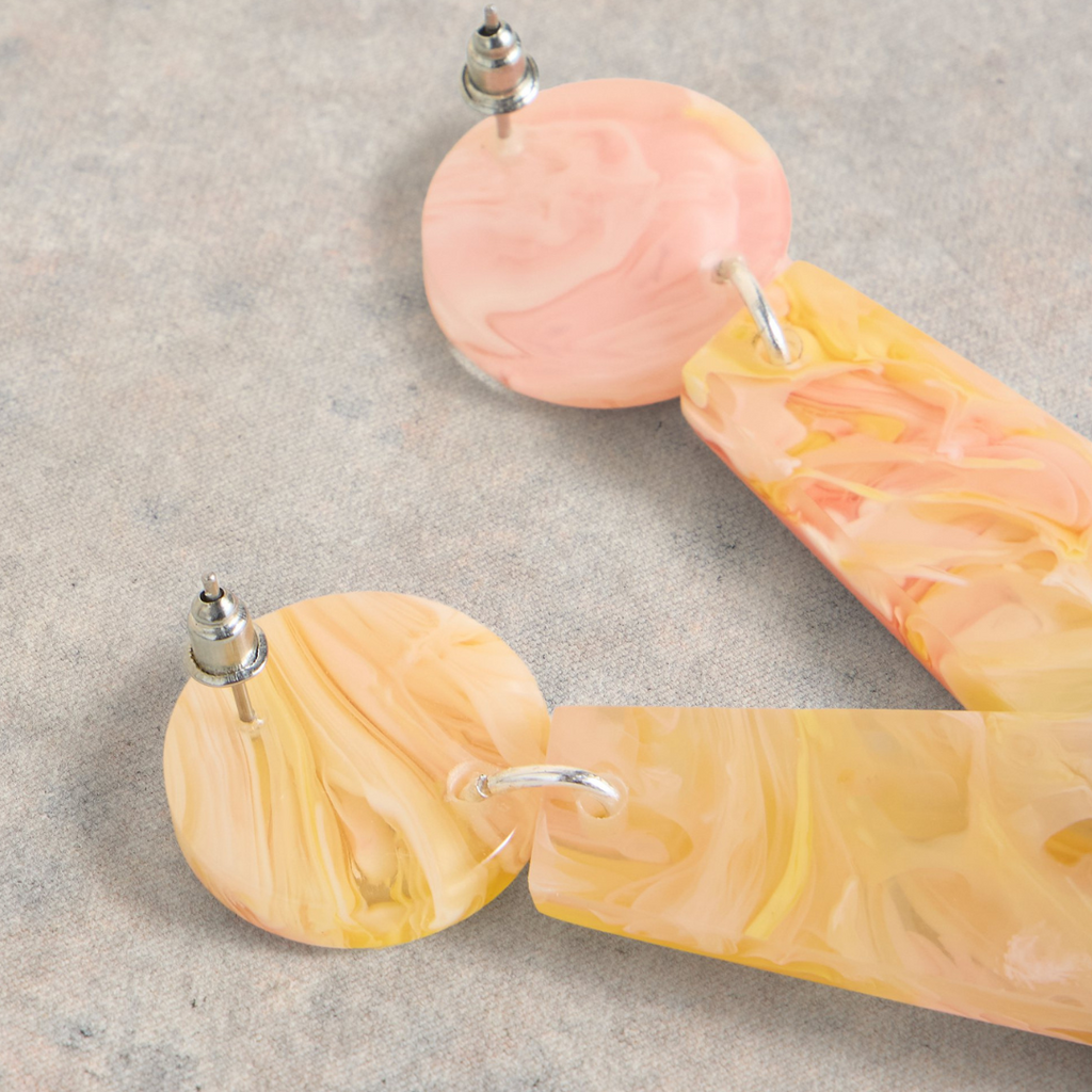 Pair of peach and yellow marbled resin earrings.