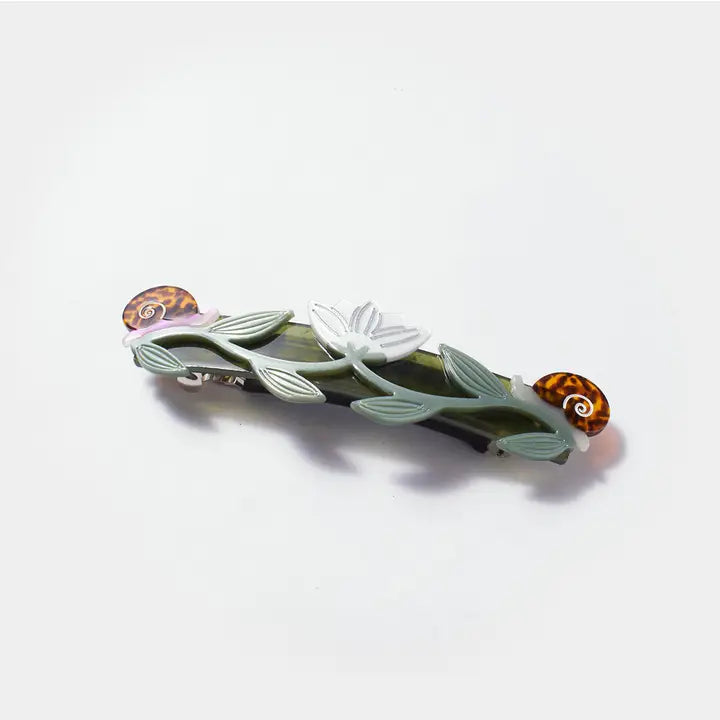 Decorative hair clip with leaf and shell design on a white background