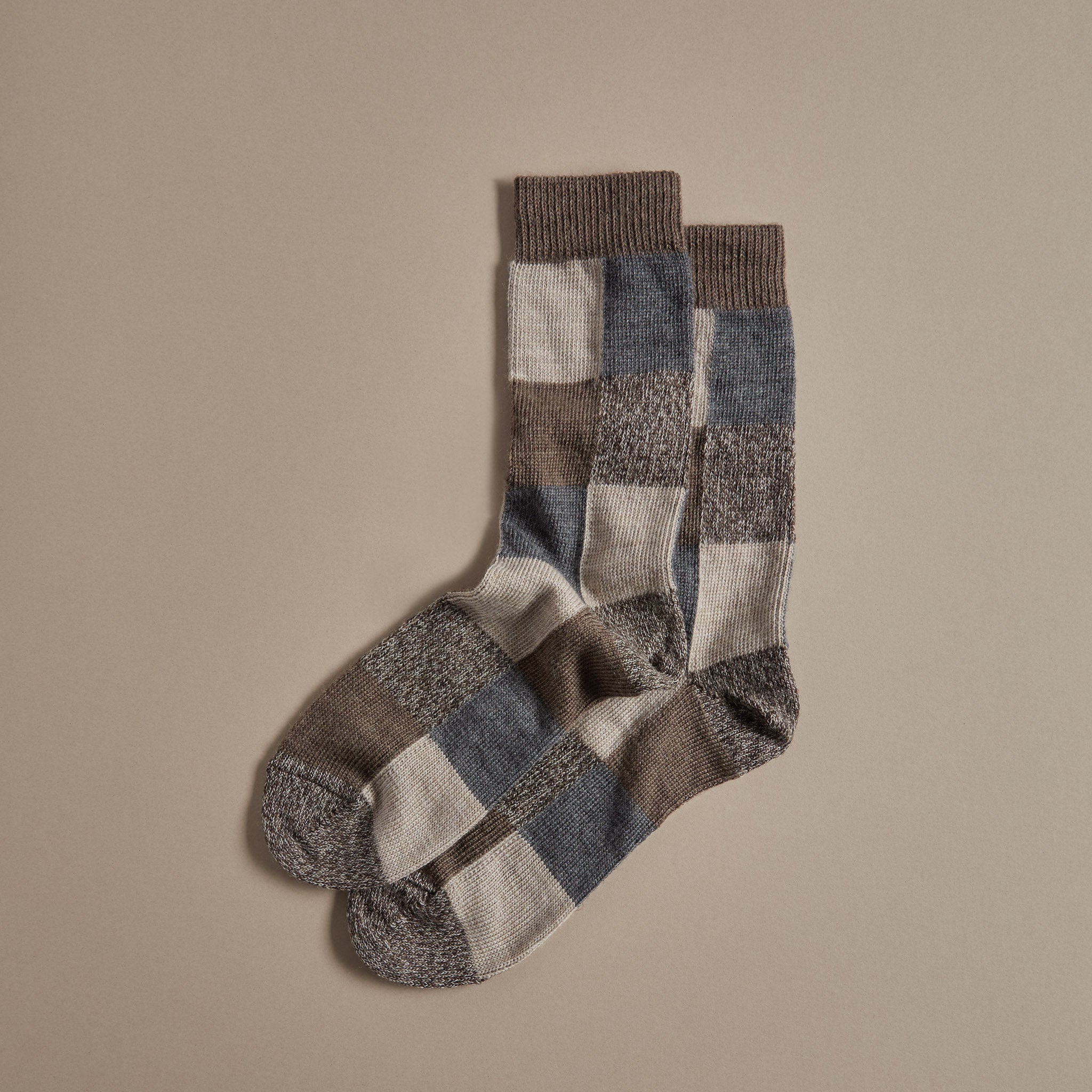 Pair of brown, beige, and gray wool socks with a checkered pattern.