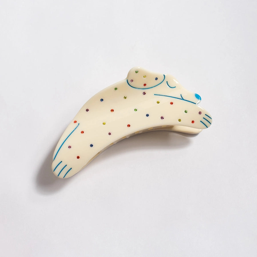 Decorative object resembling a shark with colorful polka dots on a light gray background
