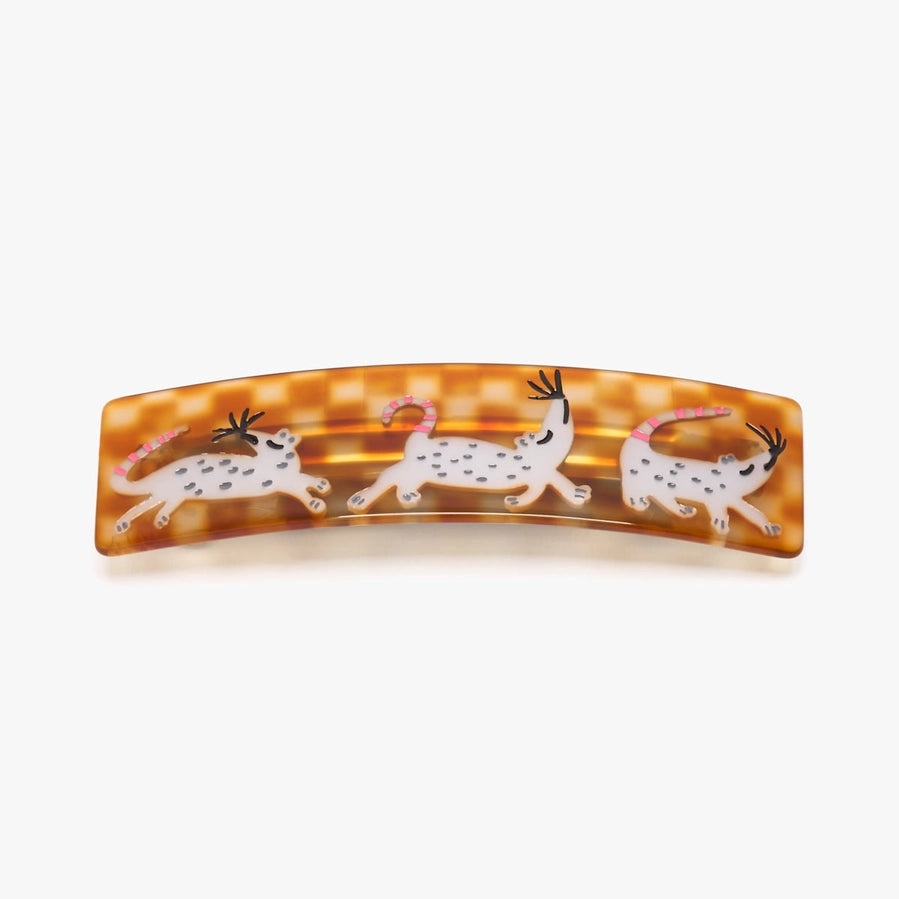 Tortoiseshell hair clip with cat designs on a white background