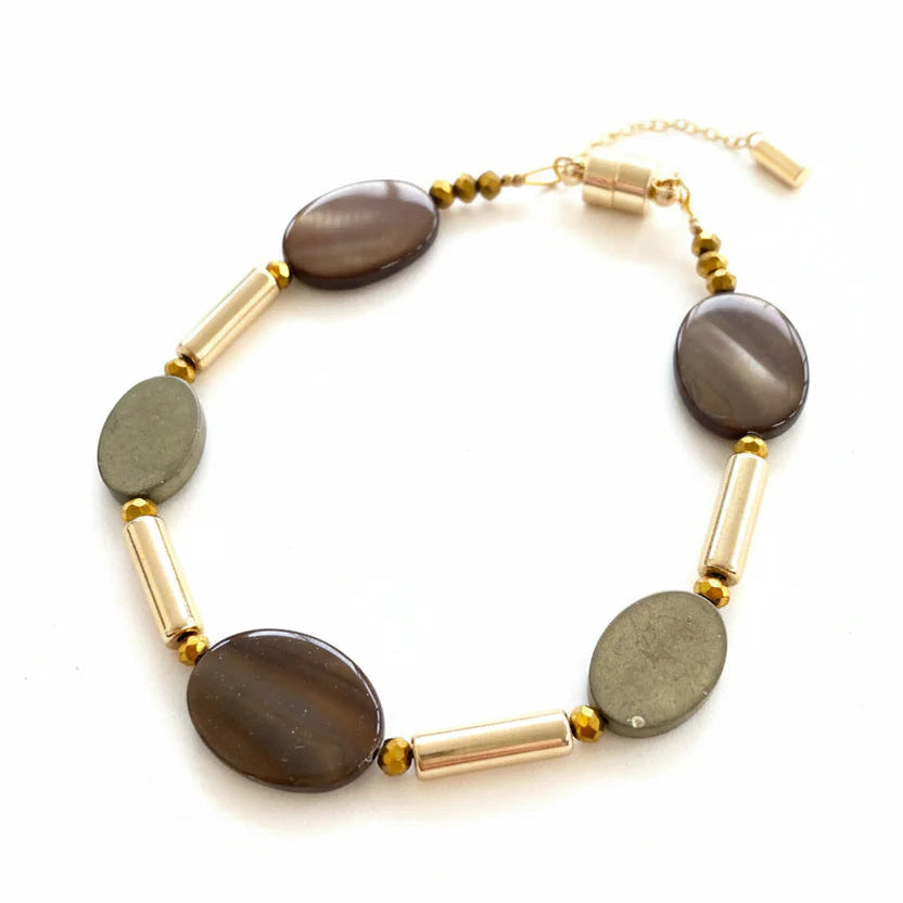 Necklace with brown oval beads and gold cylindrical beads on a white background