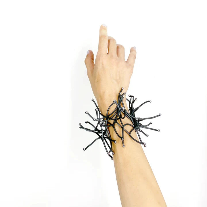 Black and silver abstract wire bracelet with radiating strands.