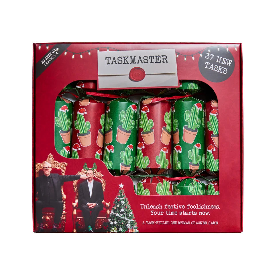 Taskmaster Christmas Cracker Game set in a red box with a clear window showing green cactus-patterned crackers, on a white background.