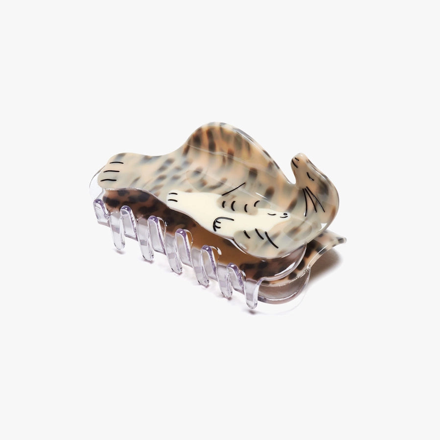 A hair clip in the shape of a seal holding a seal pup sits on a white background