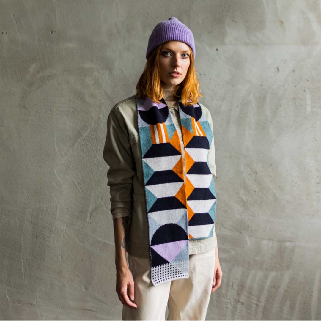 Geometric patterned wool scarf in teal, orange, purple, and white.