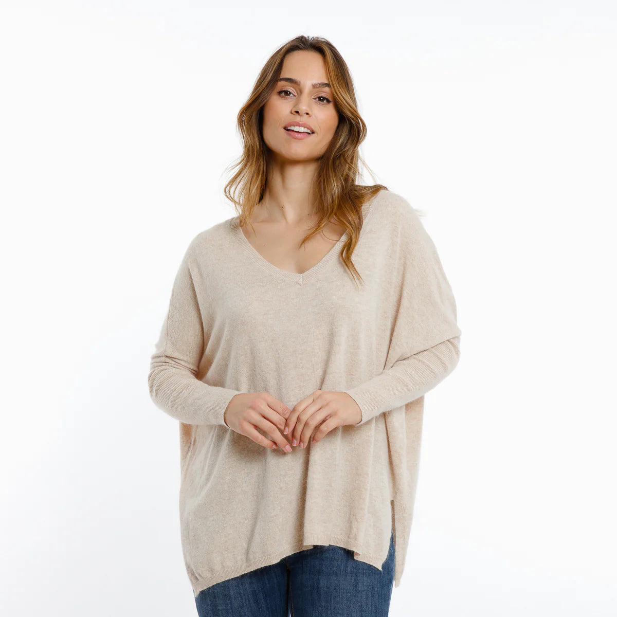 Woman wearing a beige sweater on a white background