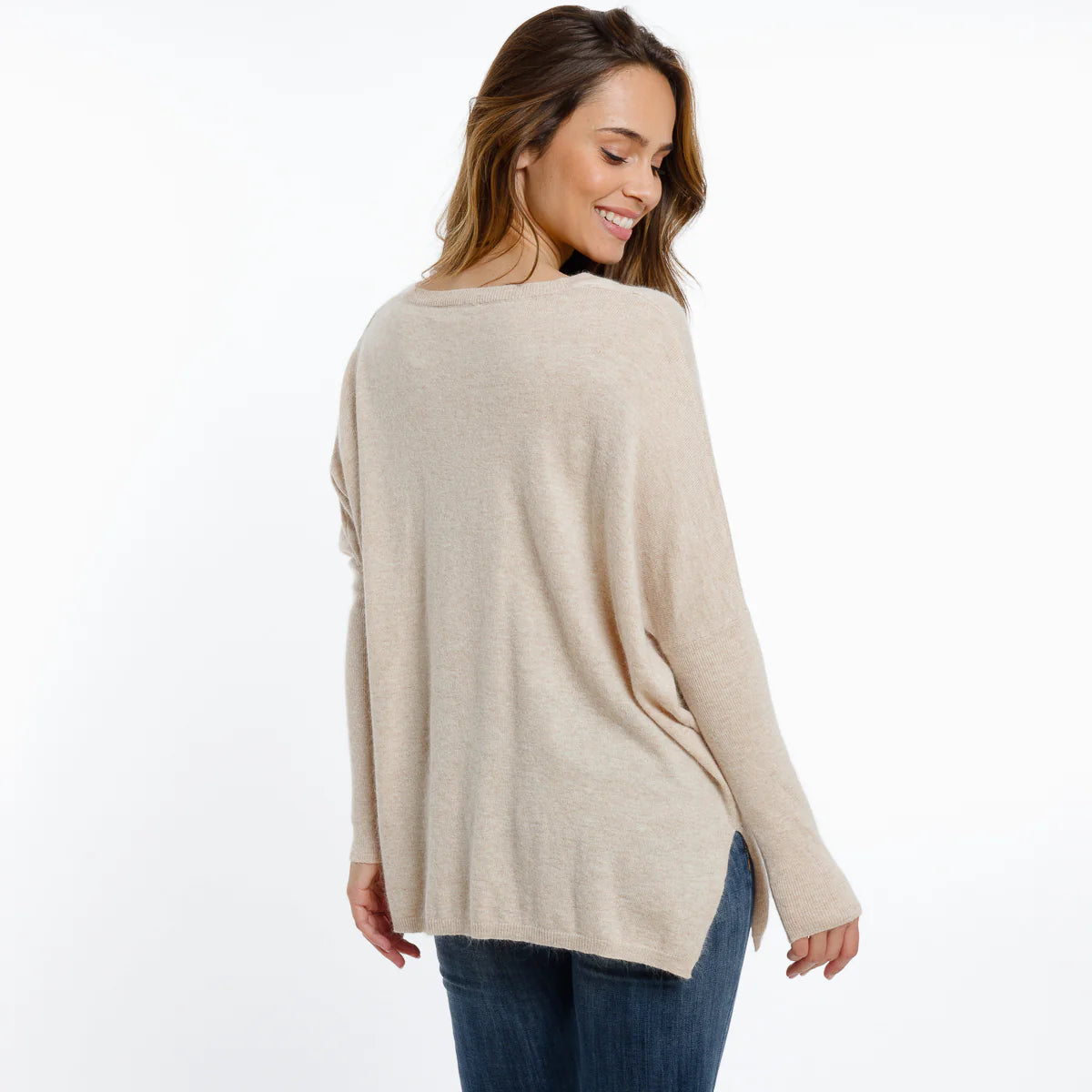 Woman wearing a beige sweater on a white background
