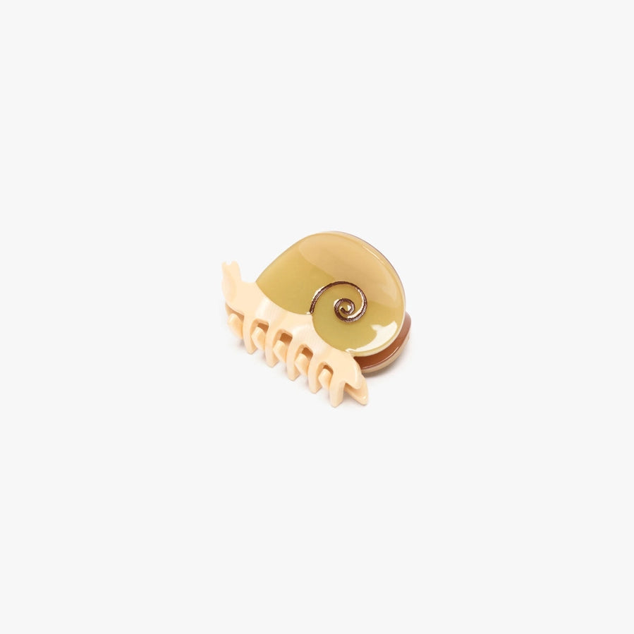 A small shell-shaped hair claw clip designed to look like a snail, featuring a glossy beige shell top and a cream-colored plastic claw base, shown on a plain light gray background.