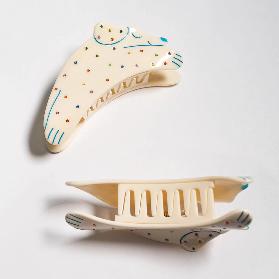 Decorative ceramic item with a boomerang-shaped design on a light gray background