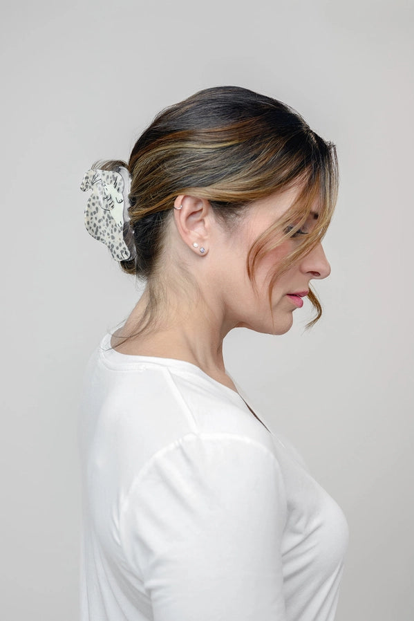 A woman with a seal shaped hair accessory against a plain background