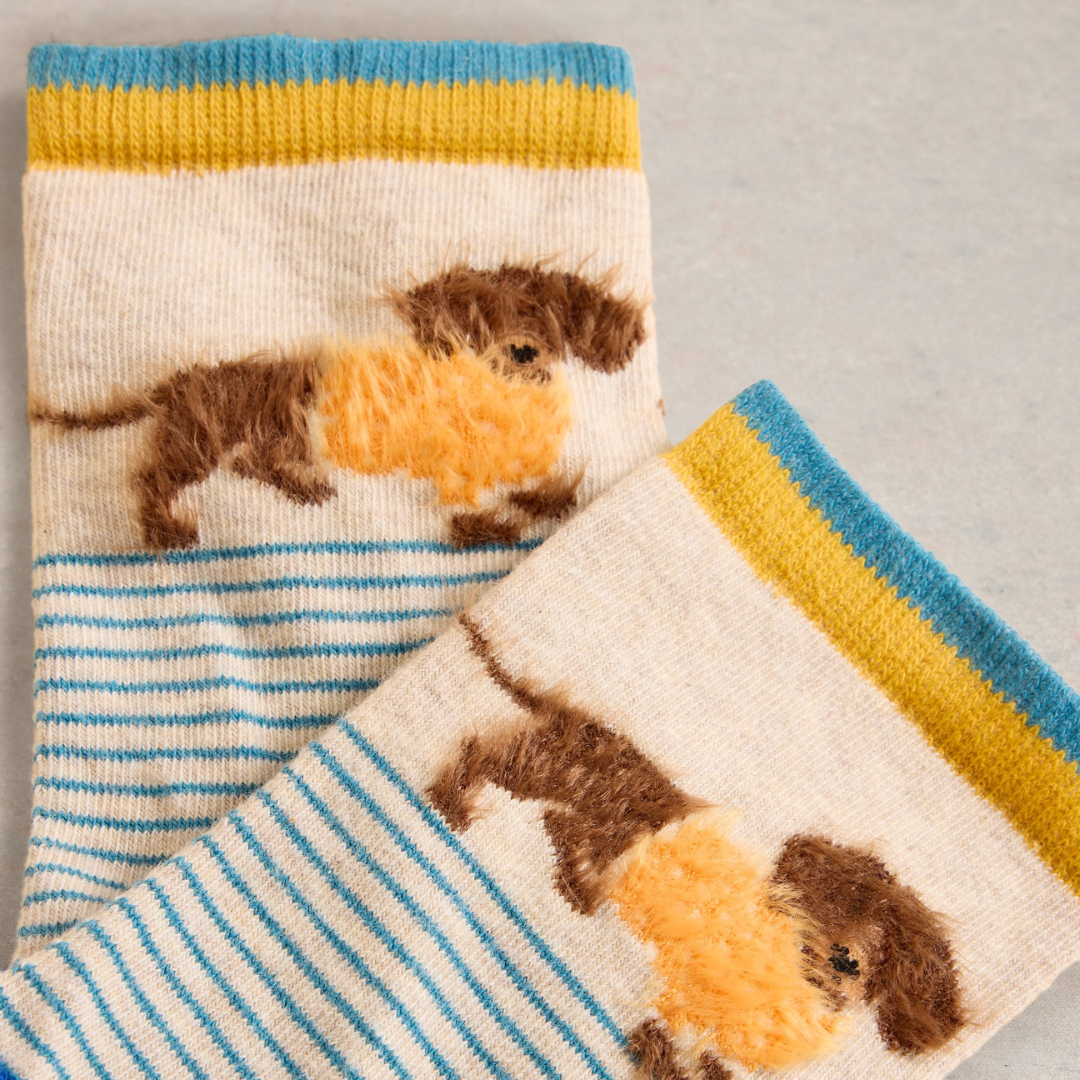 Cream-colored socks with blue and gold stripes and a repeating pattern of brown dachshunds carrying orange fluff.