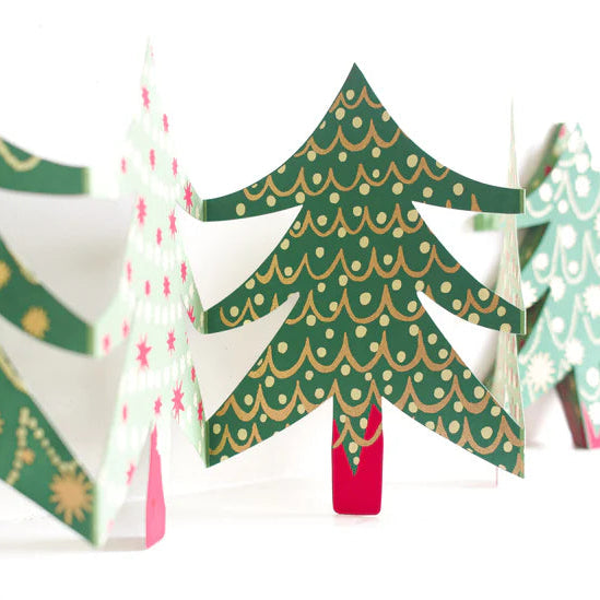 Decorative paper Christmas trees with green, red, and white patterns on a white background.