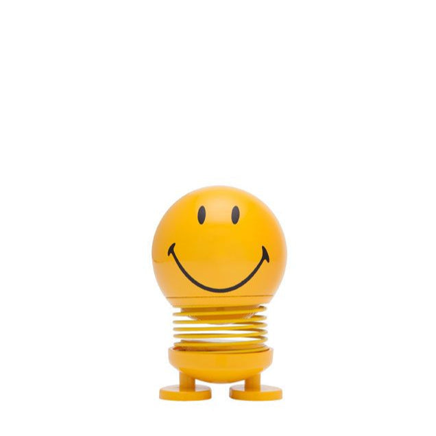 Yellow smiley face bobblehead toy on a spring.