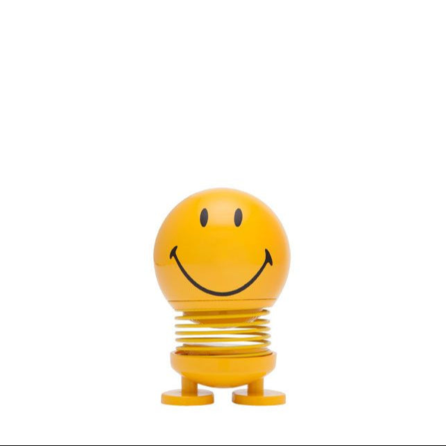 Yellow smiley face bobblehead toy on a spring.