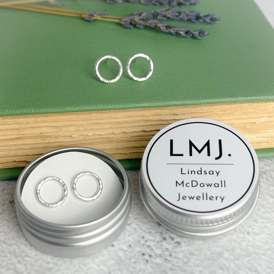 Pair of small, hammered silver circle stud earrings in a silver tin.