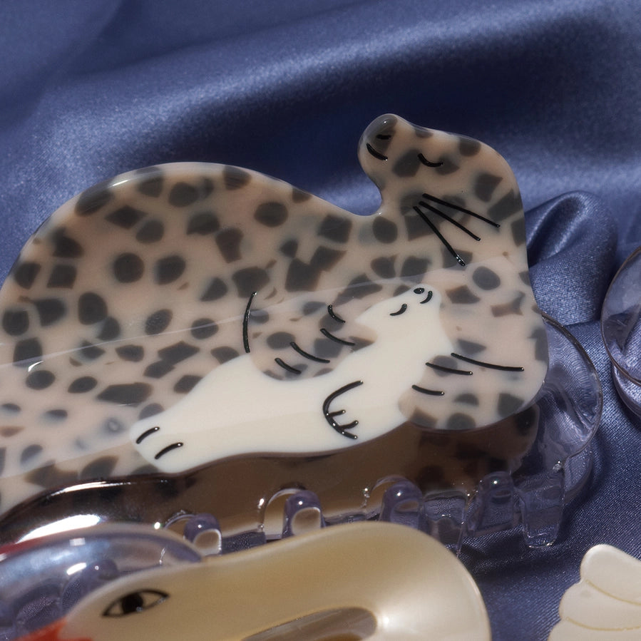Seal-shaped hair clip sits on a blue fabric background