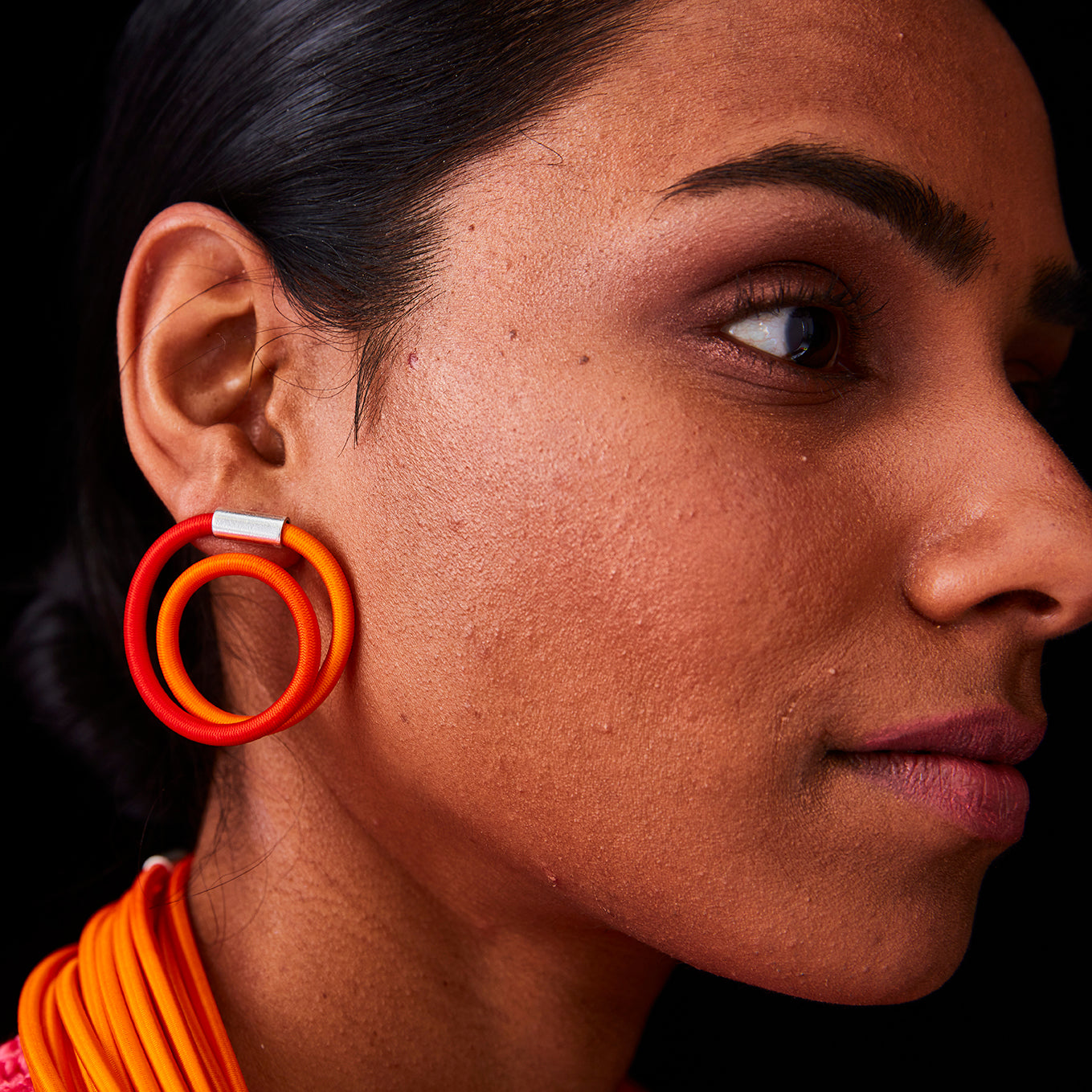 Double-hoop earrings in ombre orange and red, with a silver connector.