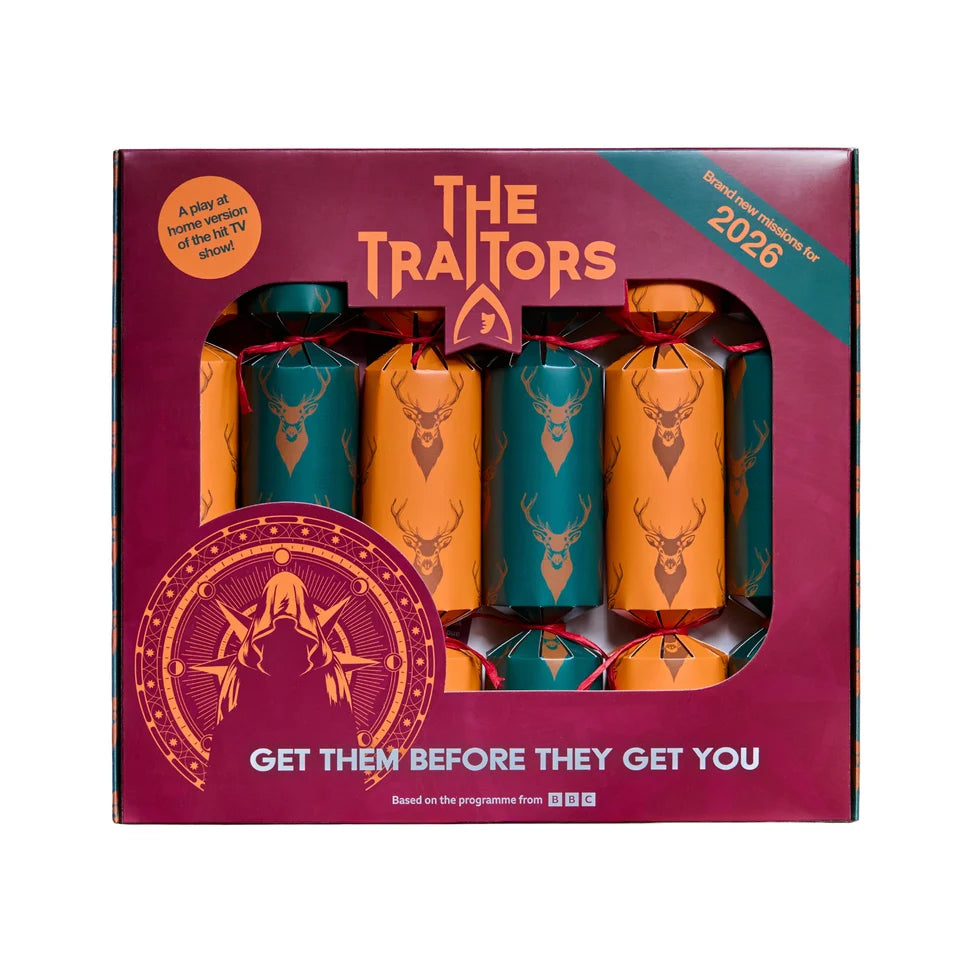The Traitors Christmas crackers set in a magenta box with a clear window showing four decorated crackers in orange and teal with deer head designs.