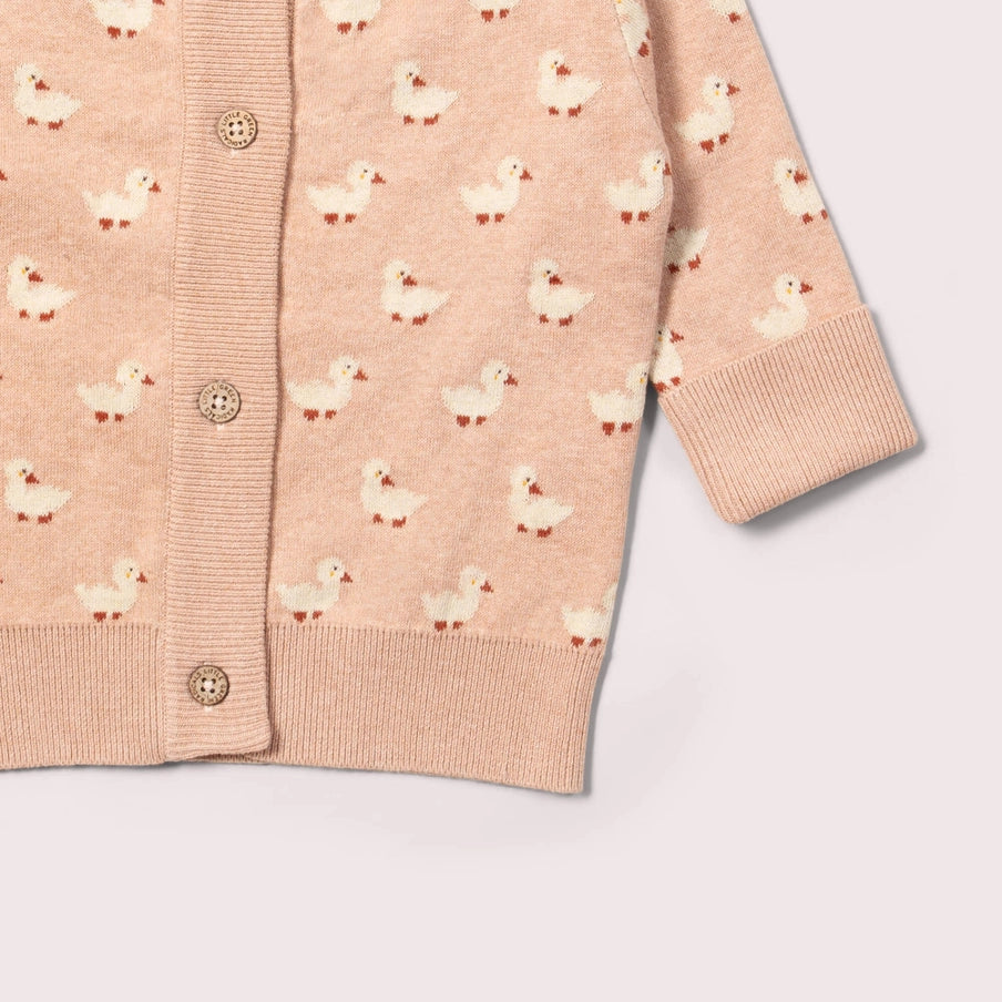 Pink cardigan with duck pattern on a light gray background