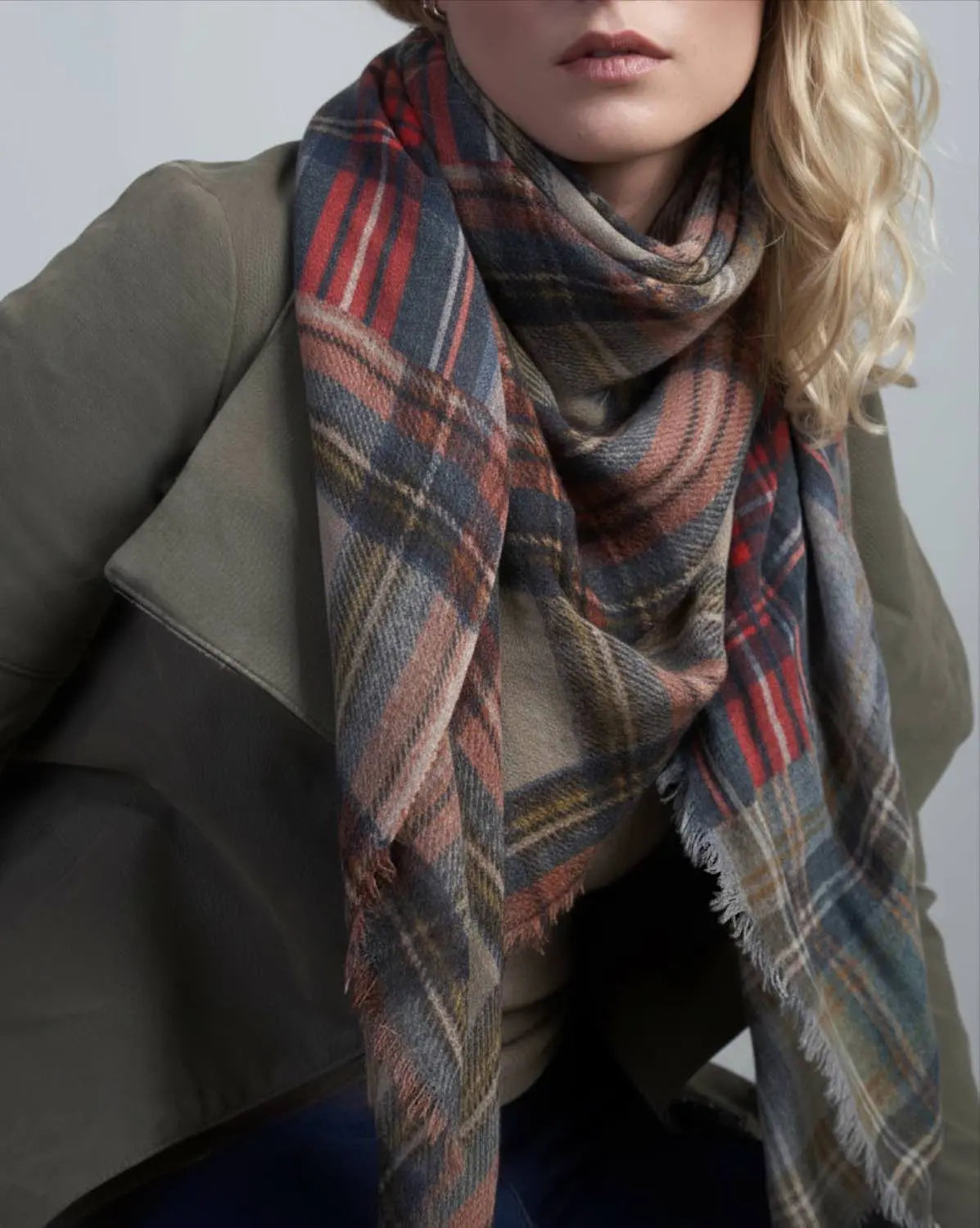 Person wearing a plaid scarf with a neutral background