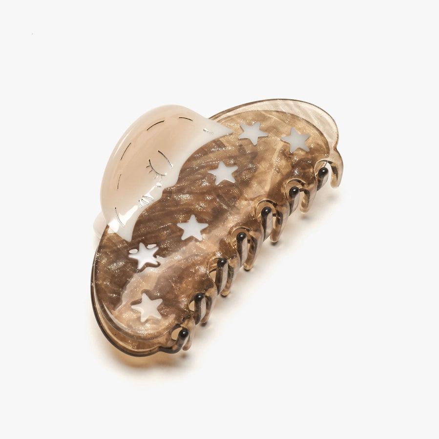Gold hair clip with star designs on a white background