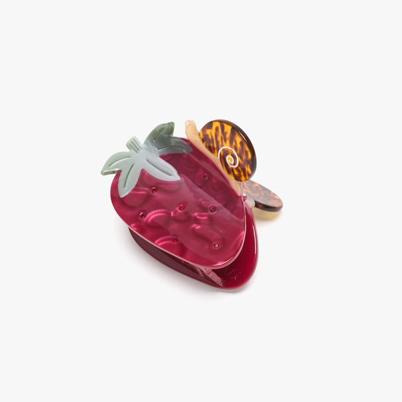 Strawberry-shaped hair clip with a tortoiseshell bow on a white background