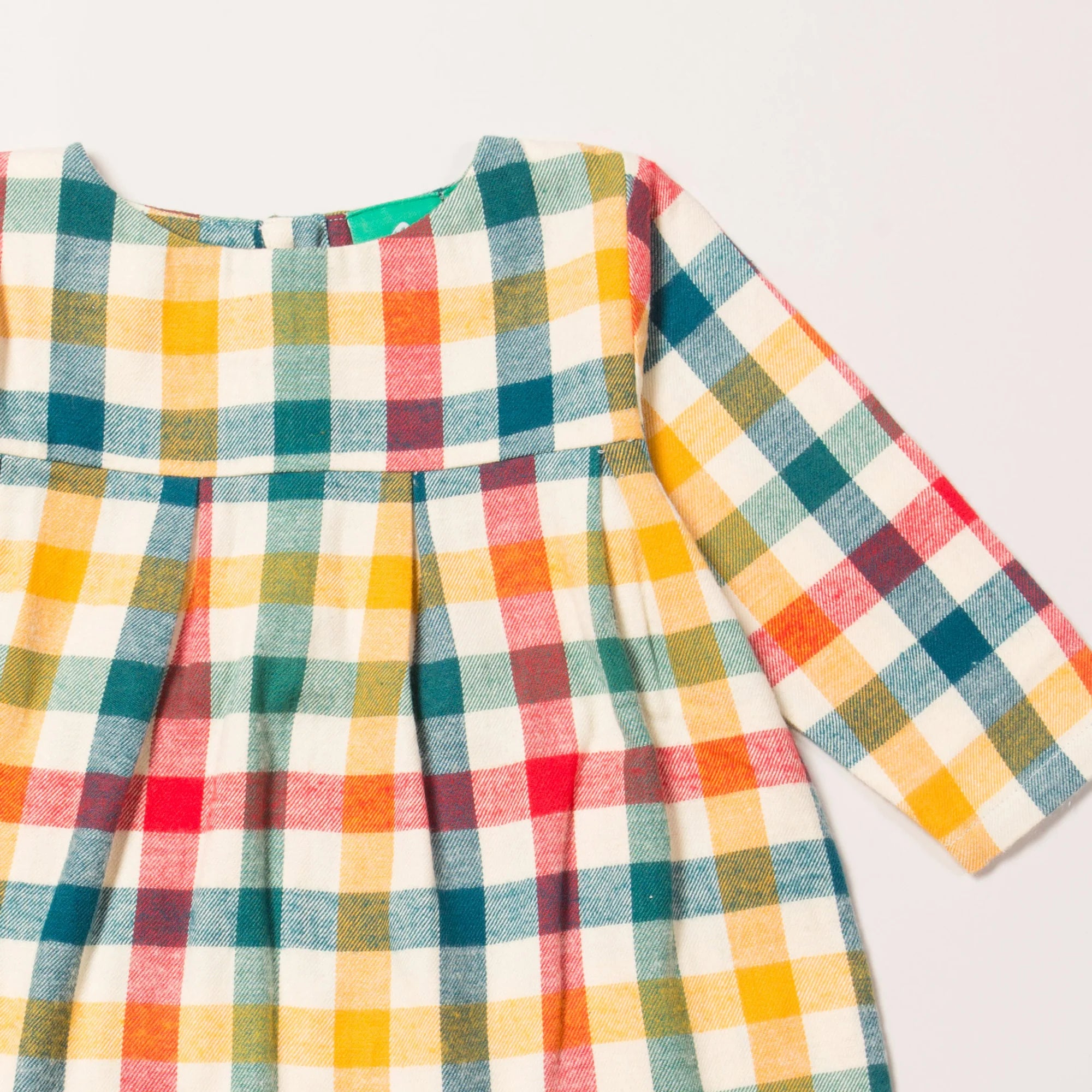 Multicolored plaid long-sleeved dress with a round neckline and pleated bodice.