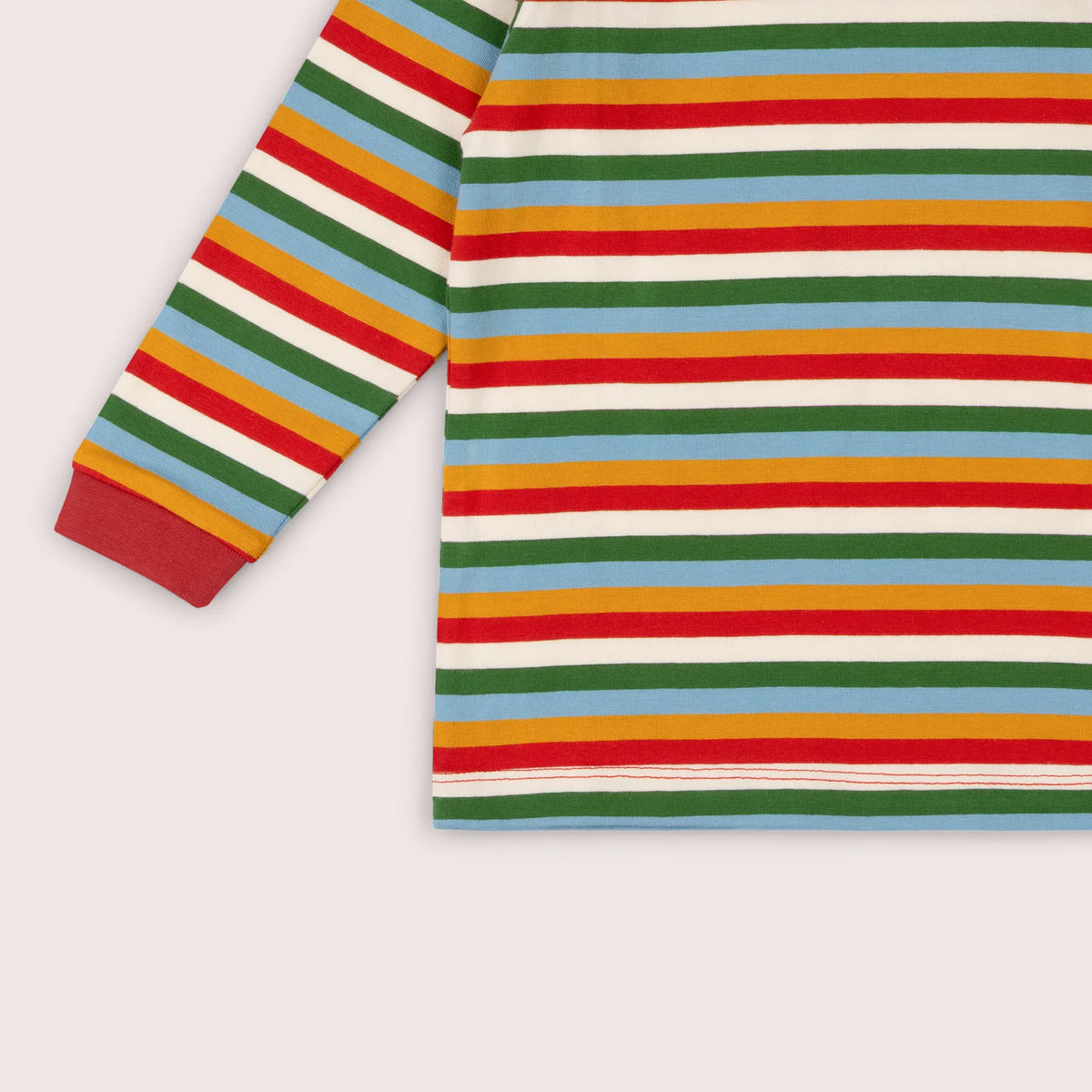A close-up of a long-sleeve striped top with horizontal bands of green, red, yellow, light blue, and white, featuring a solid red ribbed cuff.