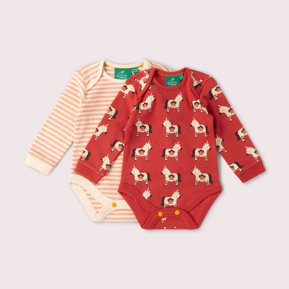 Two baby long-sleeve bodysuits laid flat on a light beige background. The front bodysuit is red with an allover horse print, and the back bodysuit is cream and peach striped.
