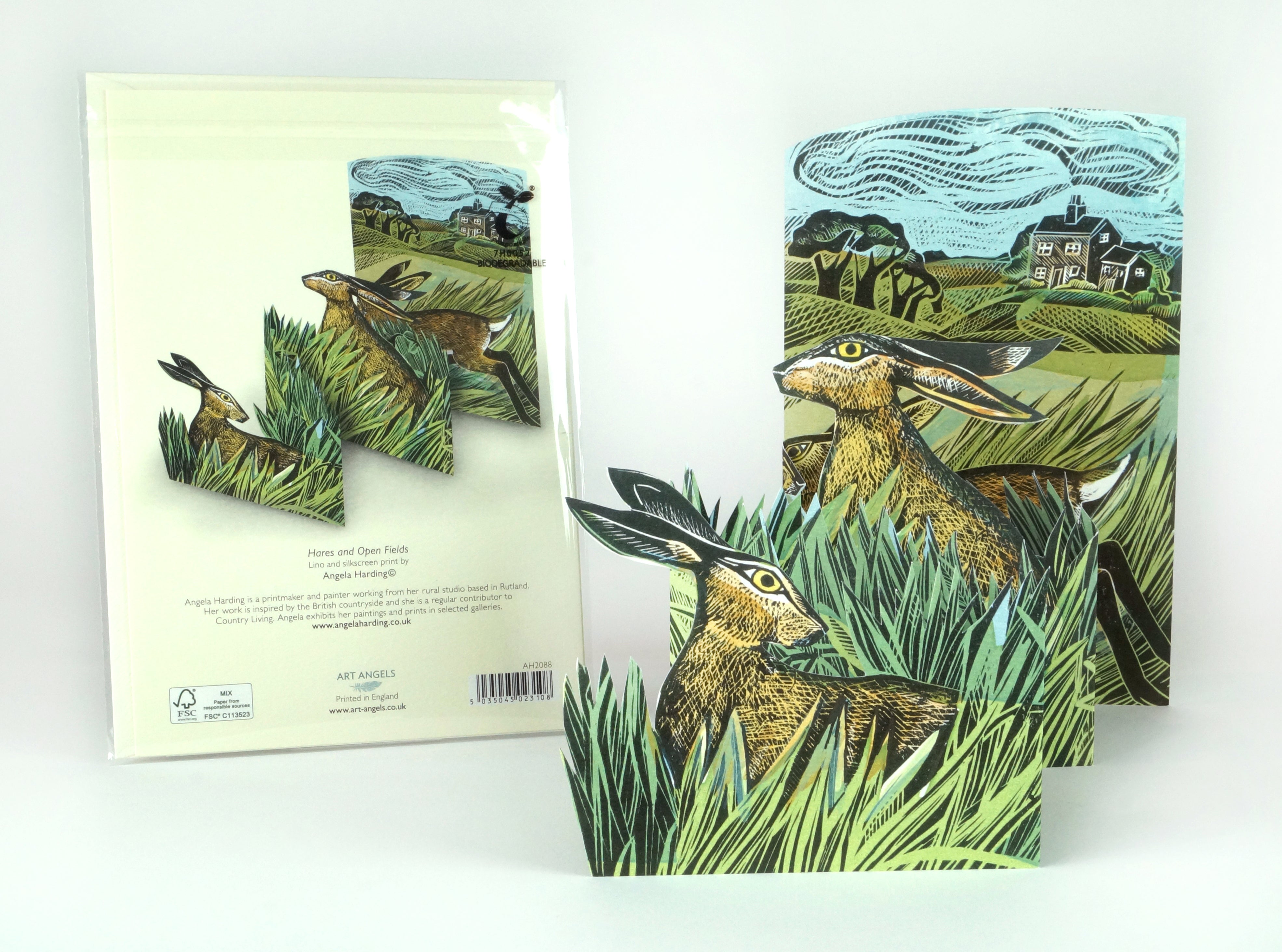Pop-up card featuring three hares in a field of tall grass, created with lino and silkscreen printing.