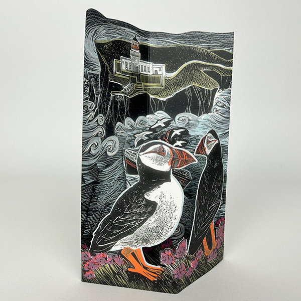 Intricate linocut print depicting two puffins perched on coastal flora, overlooking a dramatic seascape with a lighthouse.