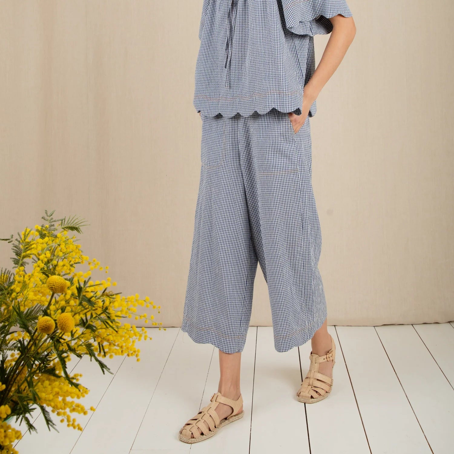Woman wearing a blue checkered outfit with a plain background